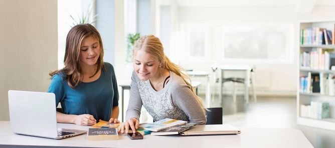 Foto: NTB scanpix Credit: Oslo kommune To jenter hjelper hverandre med lekser.