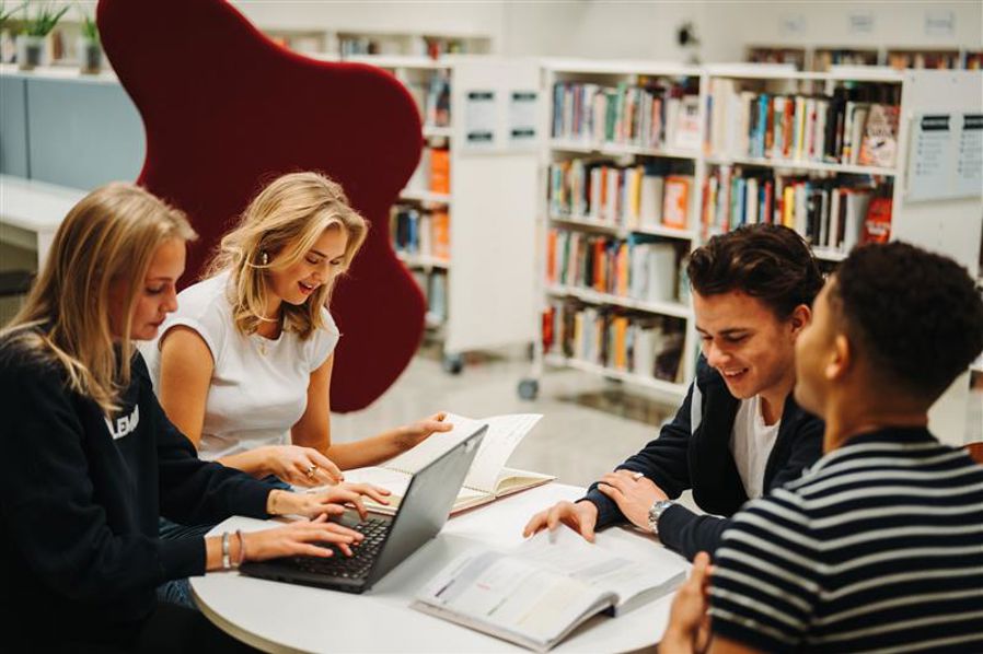 en gruppe mennesker som jobber på en bærbar PC