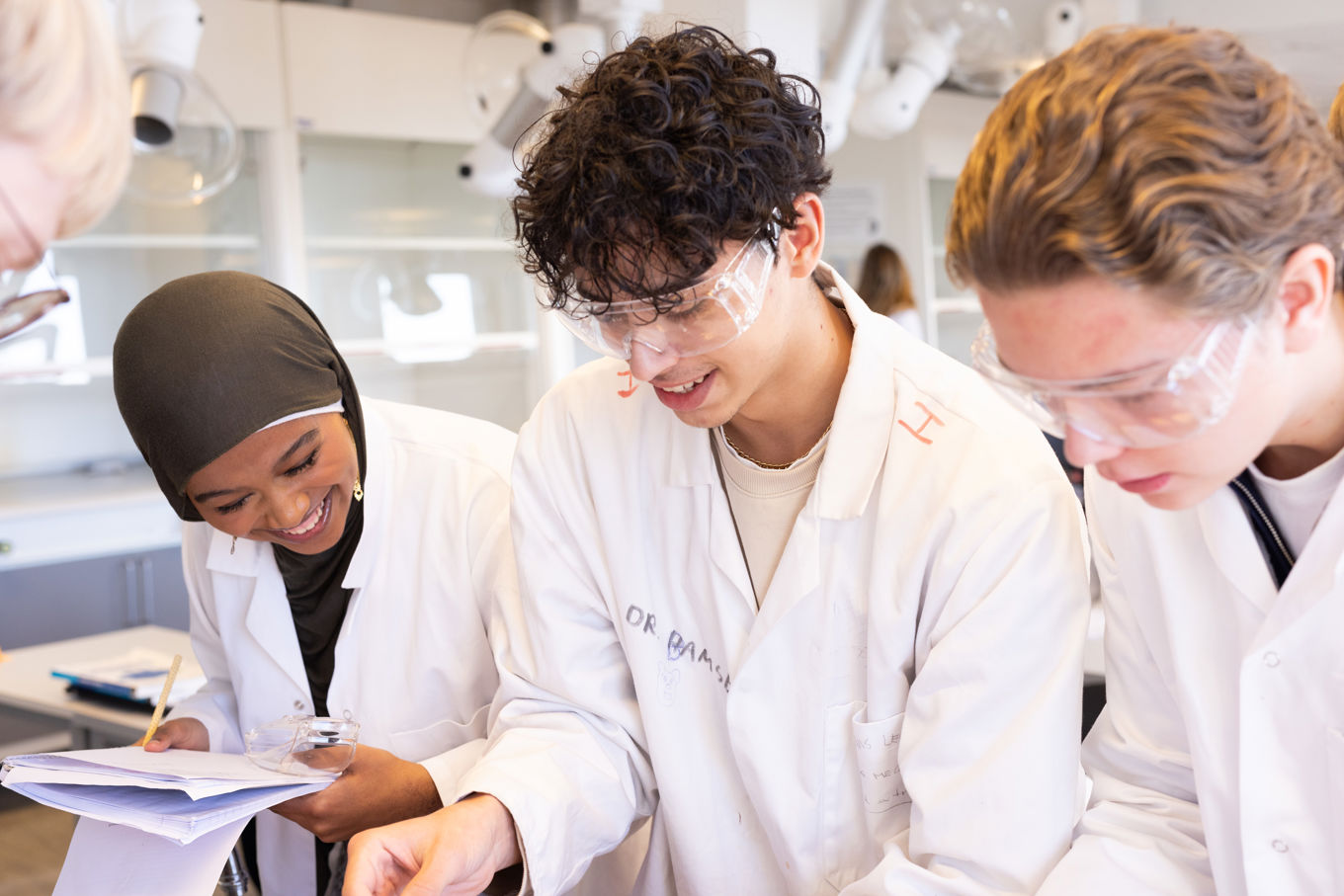 Foto: Tre elever i kjemi Tre elever ser resultater