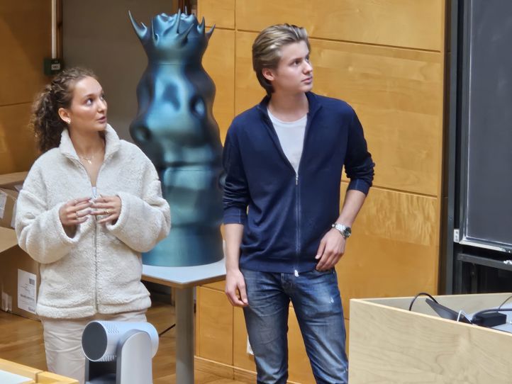 en person og en person som står foran en statue