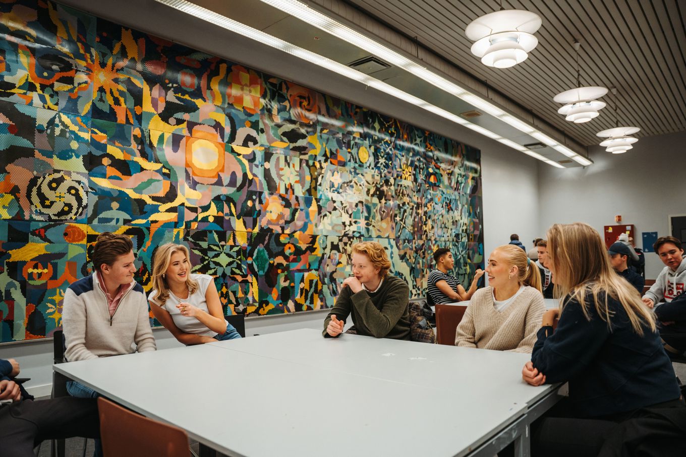 En gruppe mennesker som sitter ved et bord foran et stort kart