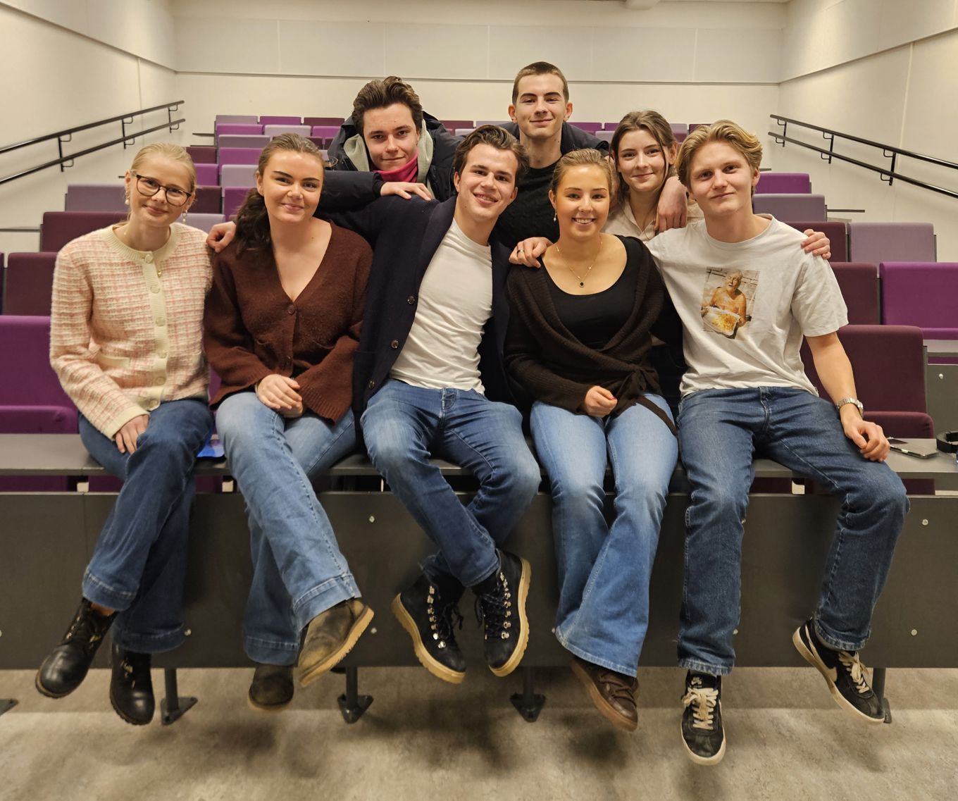 en gruppe mennesker som sitter på en benk